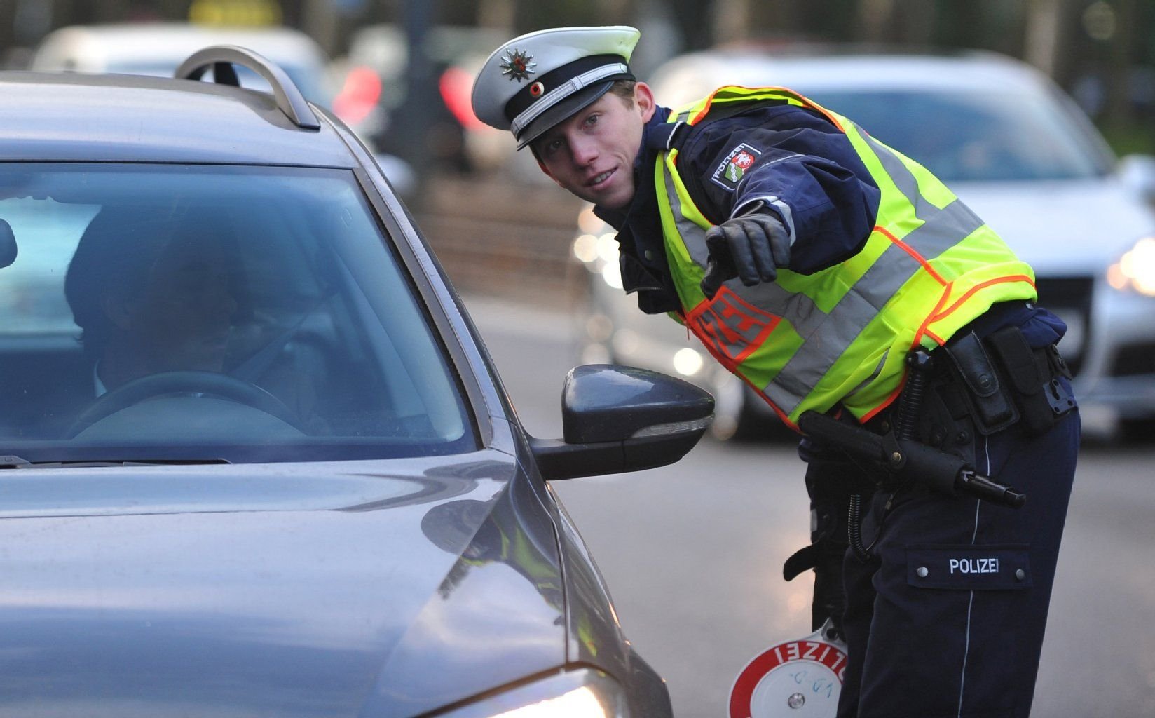 Ein Polizist hält in Düsseldorf (Nordrhein-Westfalen) einen Autofahrer nach einer Geschwindigkeitskontrolle an.