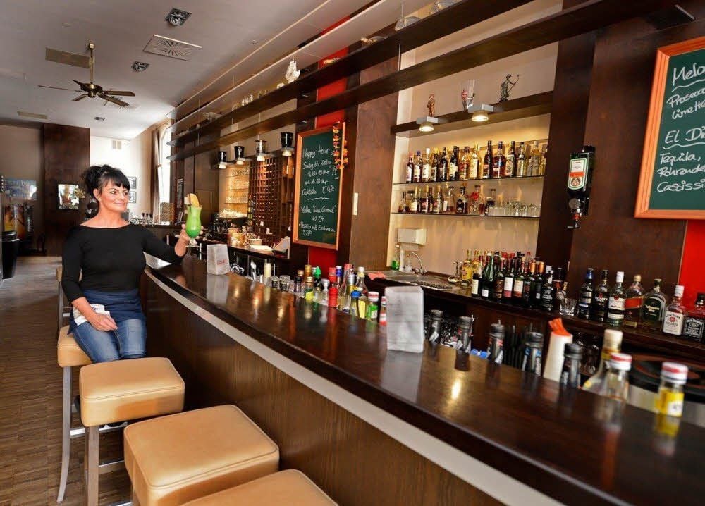 Steffi Müller im Barbereich des „Varadero“ mit dem Maradero-Cocktail. In den Regalen sind die verschiedenen Rumsorten aufgereiht.