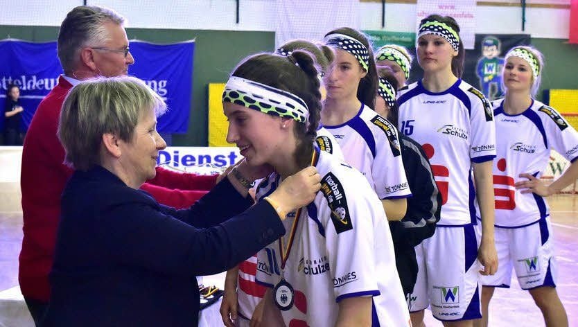 Verbandspräsidentin Elke Scholz überreicht zusammen mit UHC-Präsident Rolf Blanke die Silbermedaillen an die Weißenfelser Floorball-Frauen.