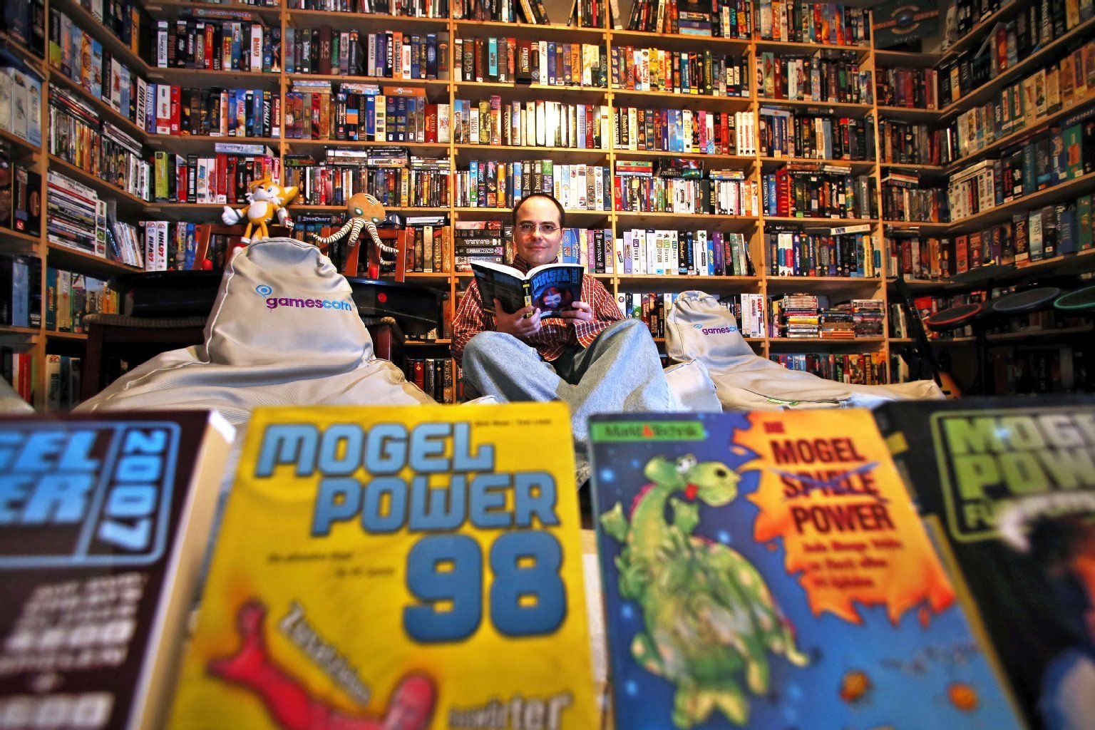 Computerspiele-Experte Rene Meyer steht in seiner privaten Sammlung und präsentiert Ausgaben seiner Zeitschrift "MogelPower" in Leipzig. Meyer trägt seit mehr als 20 Jahren alles rund um den Computer zusammen.