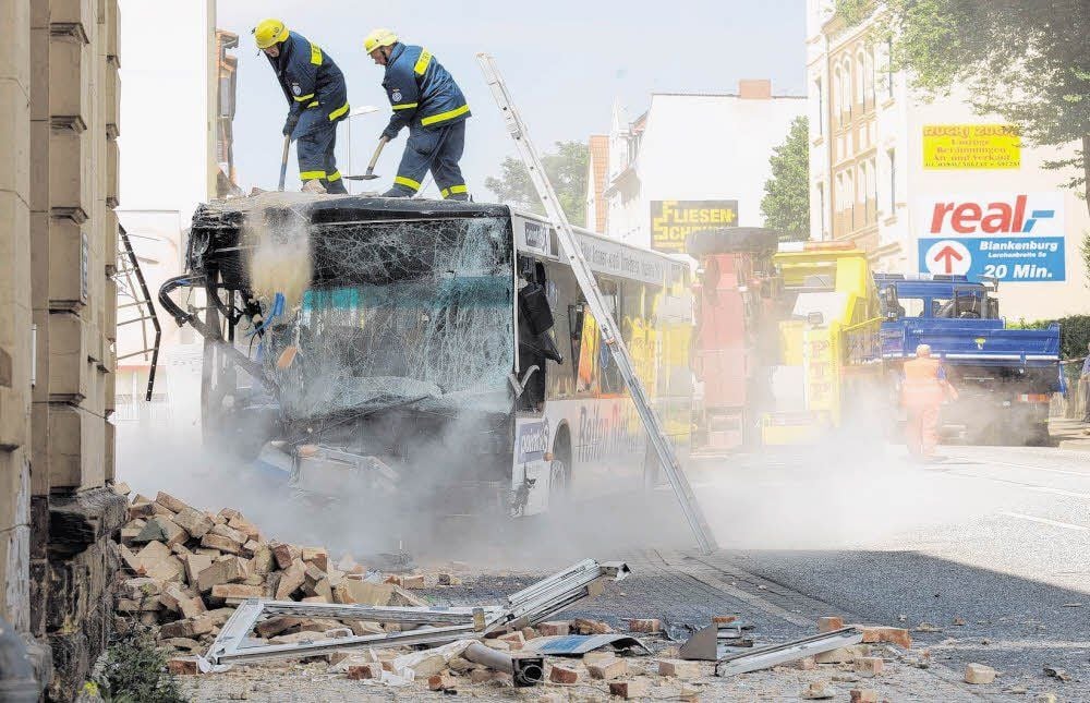 Mit einem Bergungsfahrzeug wird der Bus aus dem Haus gezogen. THW-Helfer entfernten daraufhin die Schuttreste auf dem Bus.