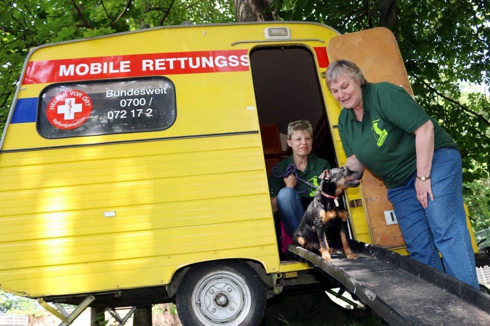 Tierheim-Mitarbeiterin Camilla Nater und Angela Nake (v.r.) testen den neuen Hundehütten-Wohnwagen mit Hündin „Fee“.