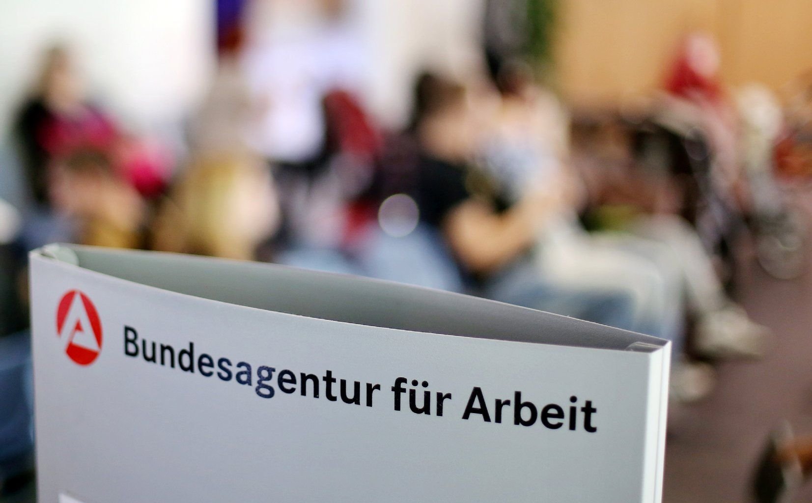 Wartende sitzen im Jobcenter.