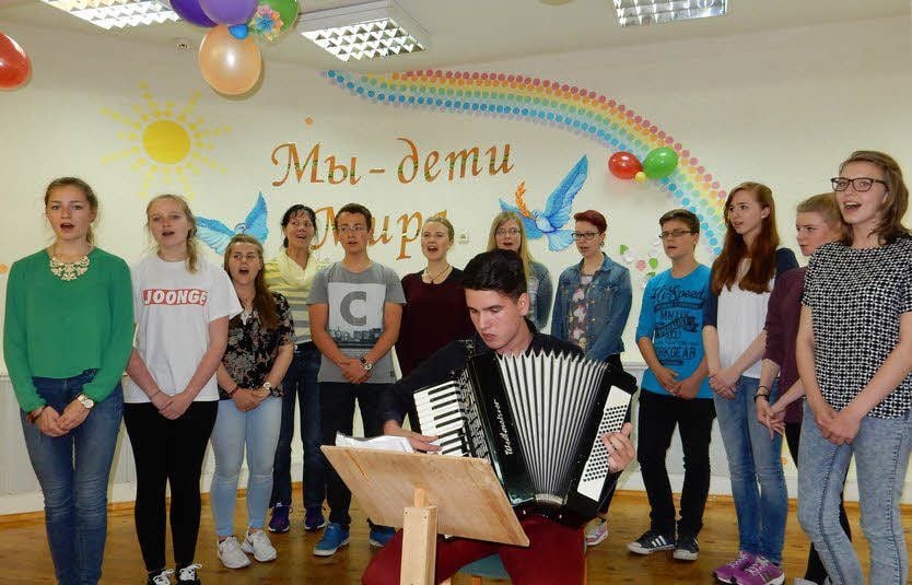 Die Jugendlichen aus Deutschland führen in Mozyr ihr Programm auf. „Wir sind Kinder des Friedens“ steht auf der Bühnenwand hinter ihnen.