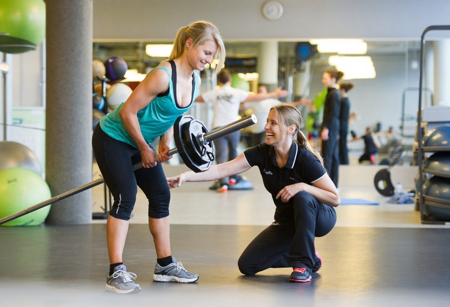 Personal Trainer wie Lonneke Boel feuern an, erklären und achten darauf, dass die Kunden die Übungen richtig machen.