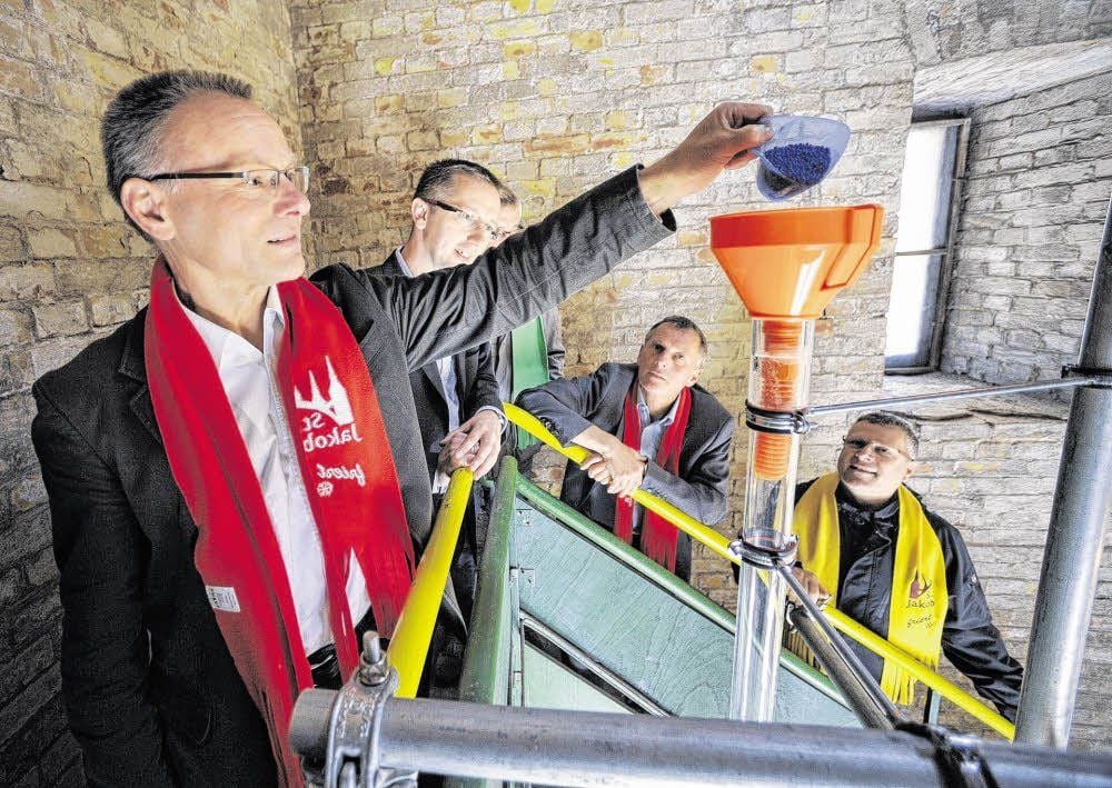 Pfarrer Wolfram Hädicke „füttert“ das Spendenthermometer mit dem ersten Granulat. Um die 10 000 Euro hat die Jakobsgemeinde für die neue Kirchenheizung bereits eingeworben - das hat die Säule an der Spendenskala auf etwa 4,5 Meter ansteigen lassen.