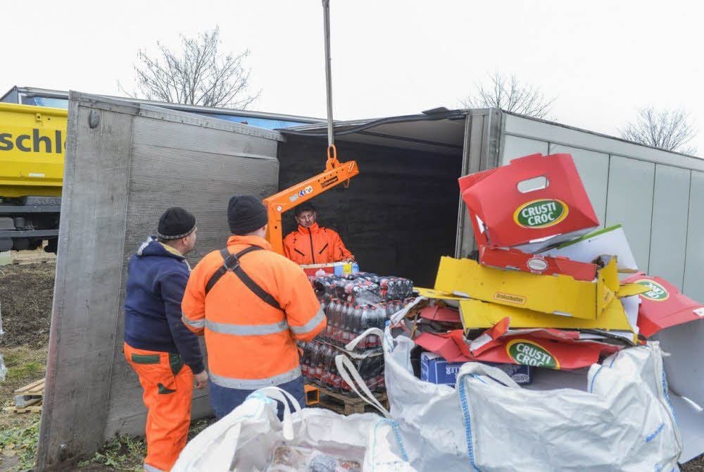 Hilfskräfte räumen die Lebensmittel aus dem Sattelzug-Koffer.