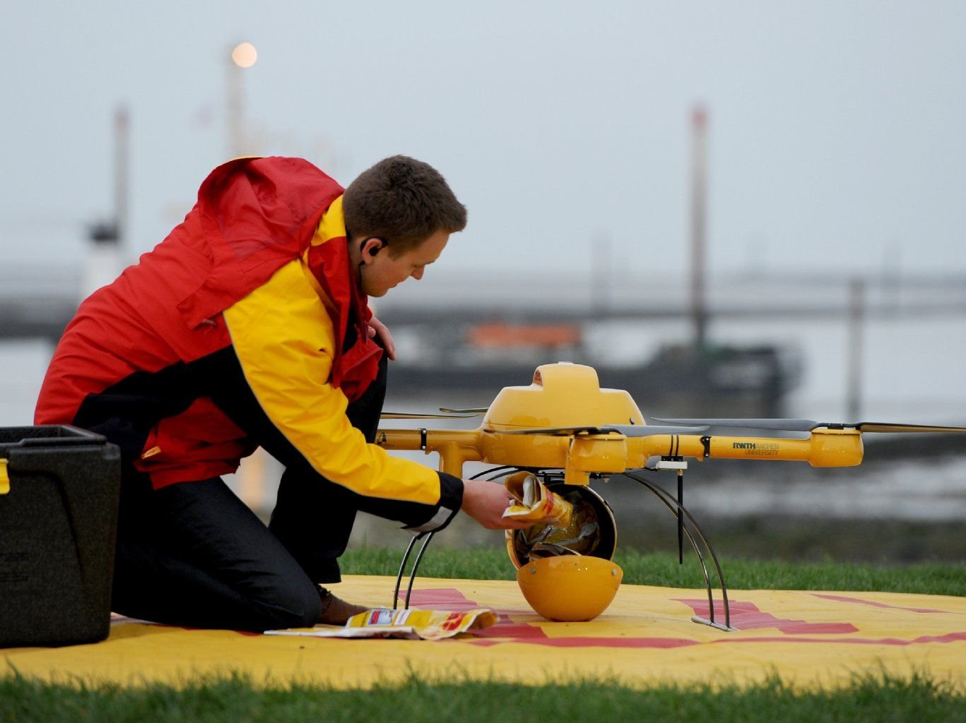 Ein DHL-Mitarbeiter belädt die Drohne mit Medikamenten.