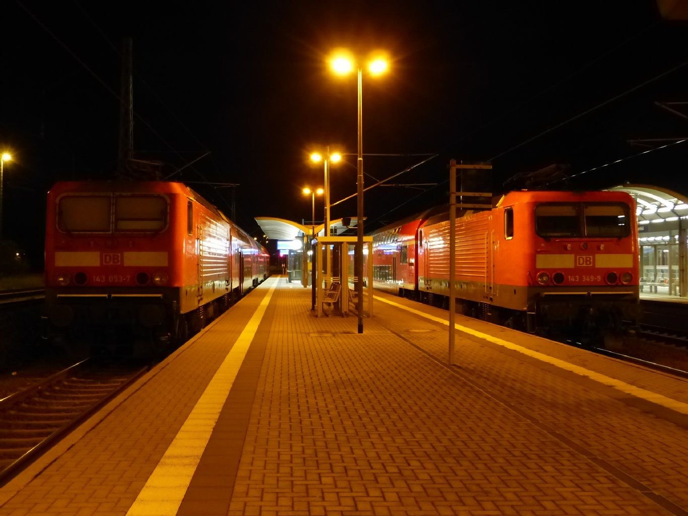 Auf dem Bitterfelder Bahnhof stehen auf den hinteren Gleisen zwei angestellte Personenzüge.