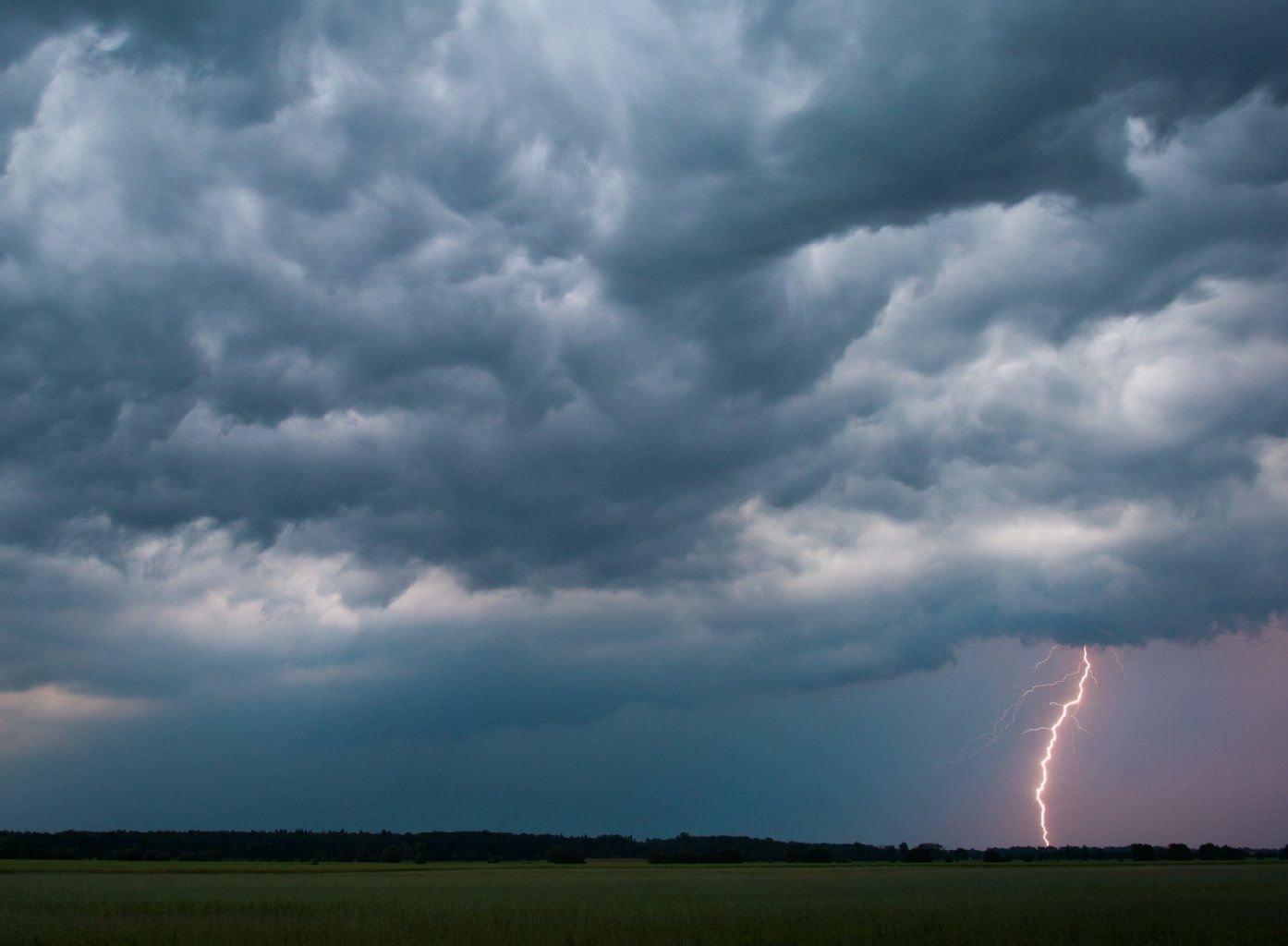 Eine Gewitterzelle zieht über ein Feld.
