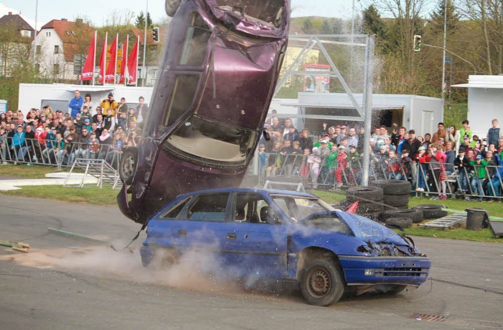 Zwei Autos werden von den Stuntleuten zu einem Schrotthaufen gefahren.