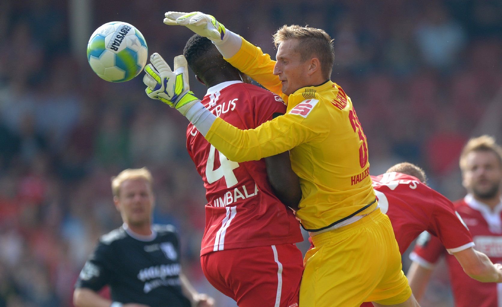 Cedric Mimbala (l) von Energie Cottbus und HFC-Torwart Pierre Kleinheider prallen in der Luft zusammen.