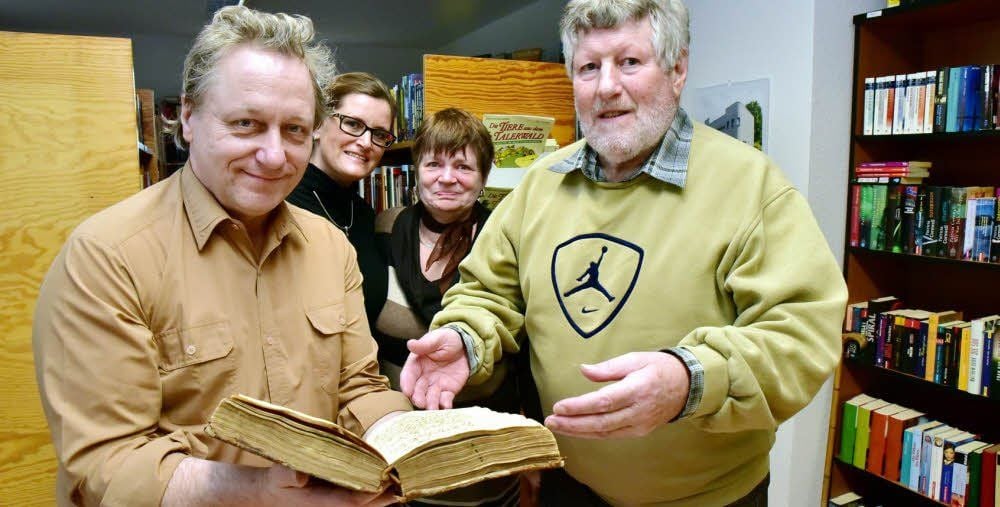 Manfred Gießler (l.) übernimmt das Innungsbuch von Dieter Huesler, im Hintergrund Ehefrau Christin und Tochter Marion.