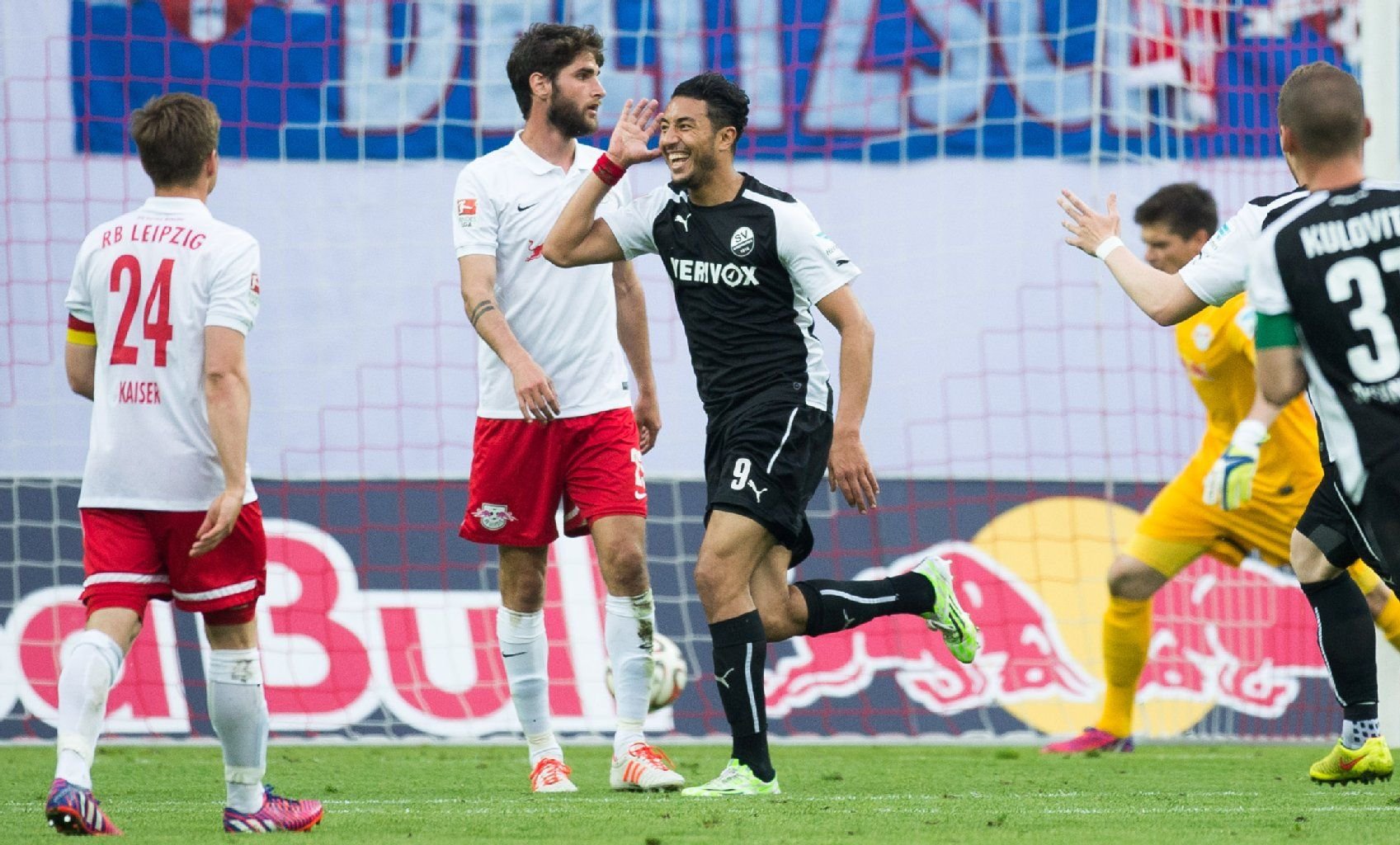 Das Nachsehen: Sandhausens Aziz Bouhaddouz (M) bejubelt seinen Treffer zum 0:3, während Leipzigs Dominik Kaiser (l), Leipzigs Niklas Hoheneder (2.v.l.) und Leipzigs Torwart Benjamin Bellot (2.v.r.) zuschauen.
