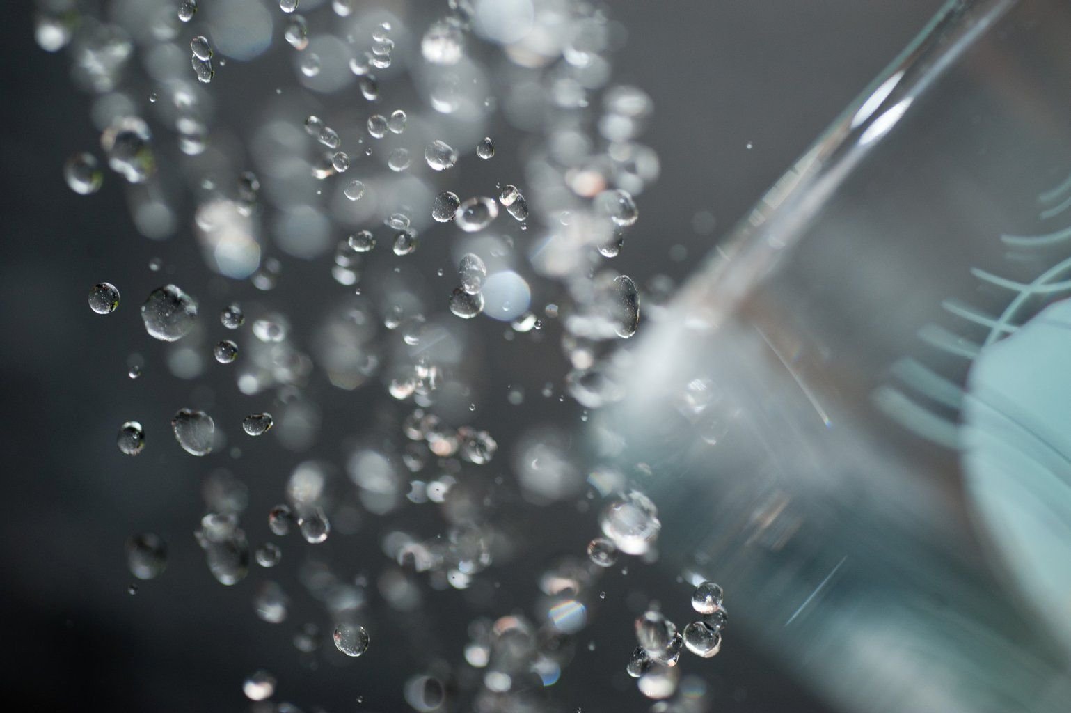 Wasser fließt aus einem Wasserhahn in ein Glas.