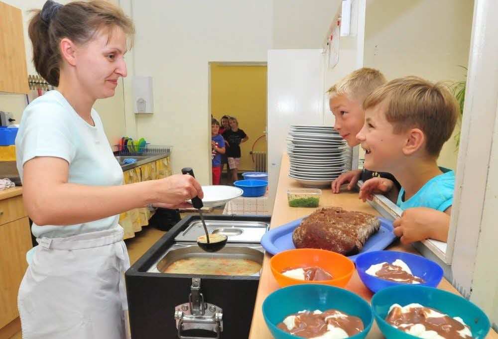 Im Hort Tagewerben: Grit Kamphoff gibt Essen von Menü-Service an Jakob Köhler und Jonas Küster aus.