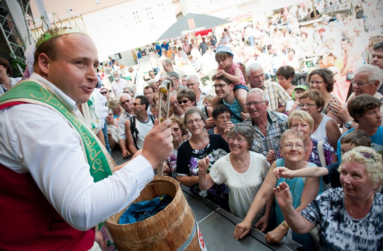 Der neue Spreewälder Gurkenkönig Andreas Wiesner verteilt beim 16. Spreewälder Gurkentag in Golßen (Brandenburg) Gurken an das Volk.