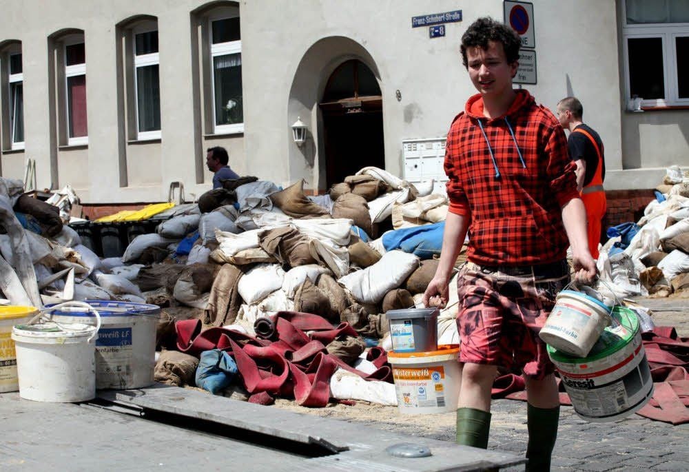 Aufräumen nach dem Hochwasser: Wie viele Betroffene packt auch Eric Amrhein (16) in Halle mit an.