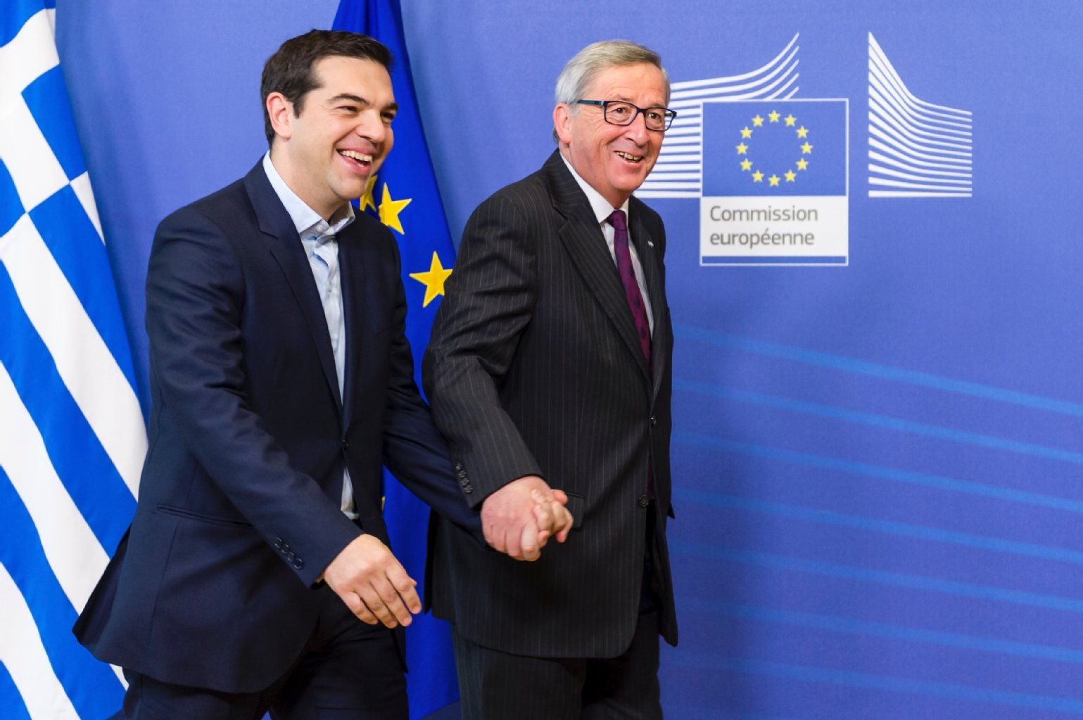 Jean-Claude Juncker geleitet Alexis Tsipras von der Bühne.