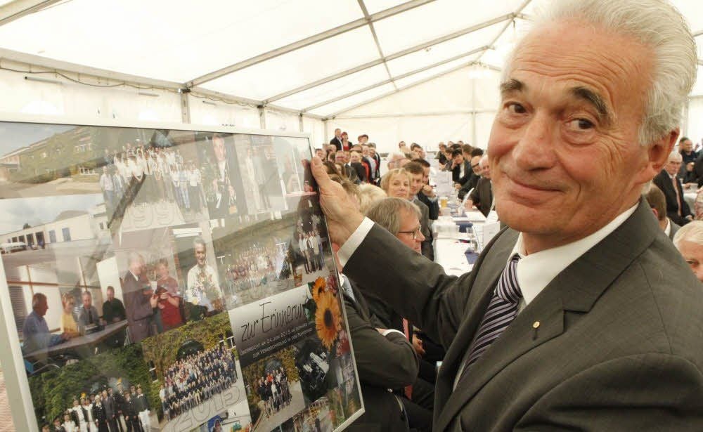 Gerhard Winkler mit dem Abschiedsgeschenk der Mitarbeiter: einer Collage von Fotos aus der Firmengeschichte.