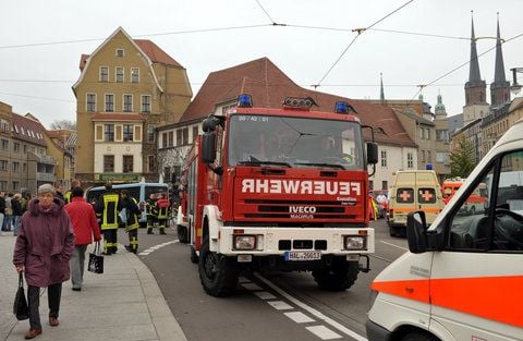 Feuerwehrautos und Rettungswagen stehen an der Klausbrücke in Halle. Rund 20 000 Menschen mussten in der Innenstadt ihre Häuser verlassen. (FOTO: DPA)