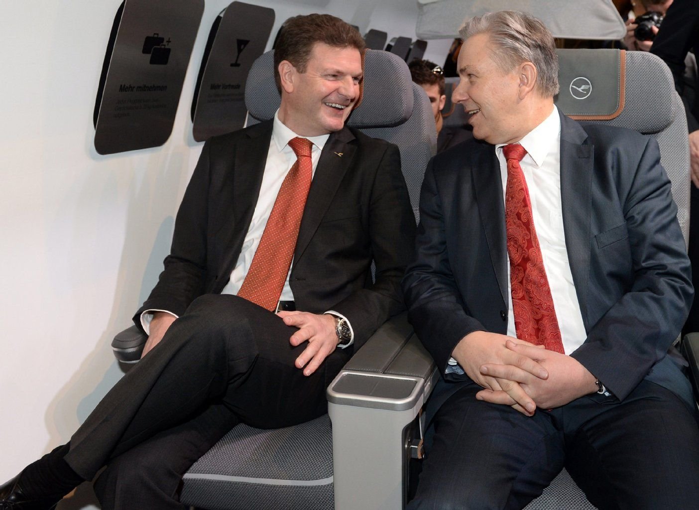 Jens Bischof, Betriebsvorstand der Lufthansa Passage (l) und Berlins Regierender Bürgermeister Klaus Wowereit sitzen in den neuen Sitzen.