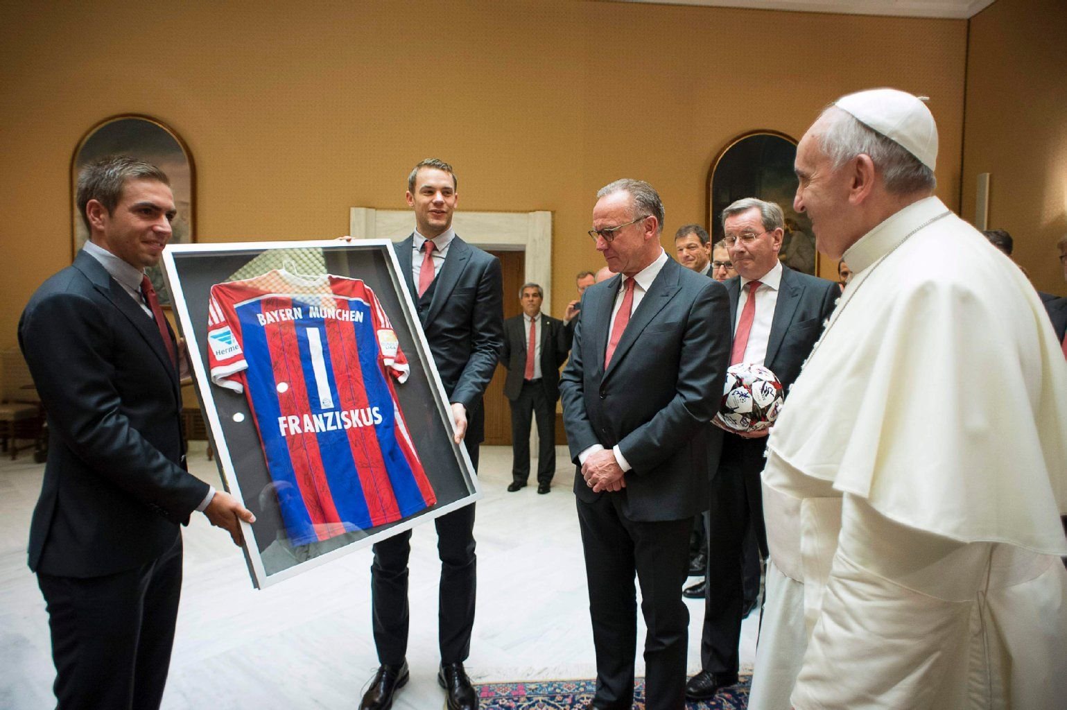 Die Spieler des FC Bayern München überreichen Papst Franziskus ein Gastgeschenk.