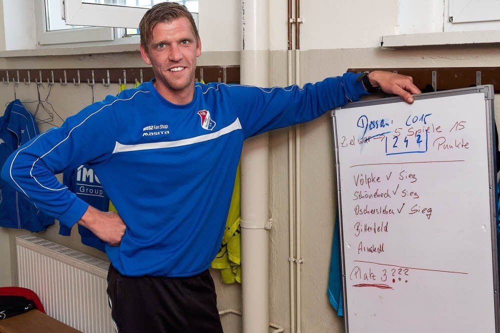 Michel Petrick, der Noch-Chef-Trainer des VfB Imo Merseburg, vor seiner „Zieltafel“. Vor Wochen malte er dort den möglichen Weg seines Teams zu Bronze auf. Fünf Siege sind dafür die Voraussetzung. Einer fehlt dem VfB Imo noch und auch ein bisschen Schützenhilfe von der Konkurrenz.