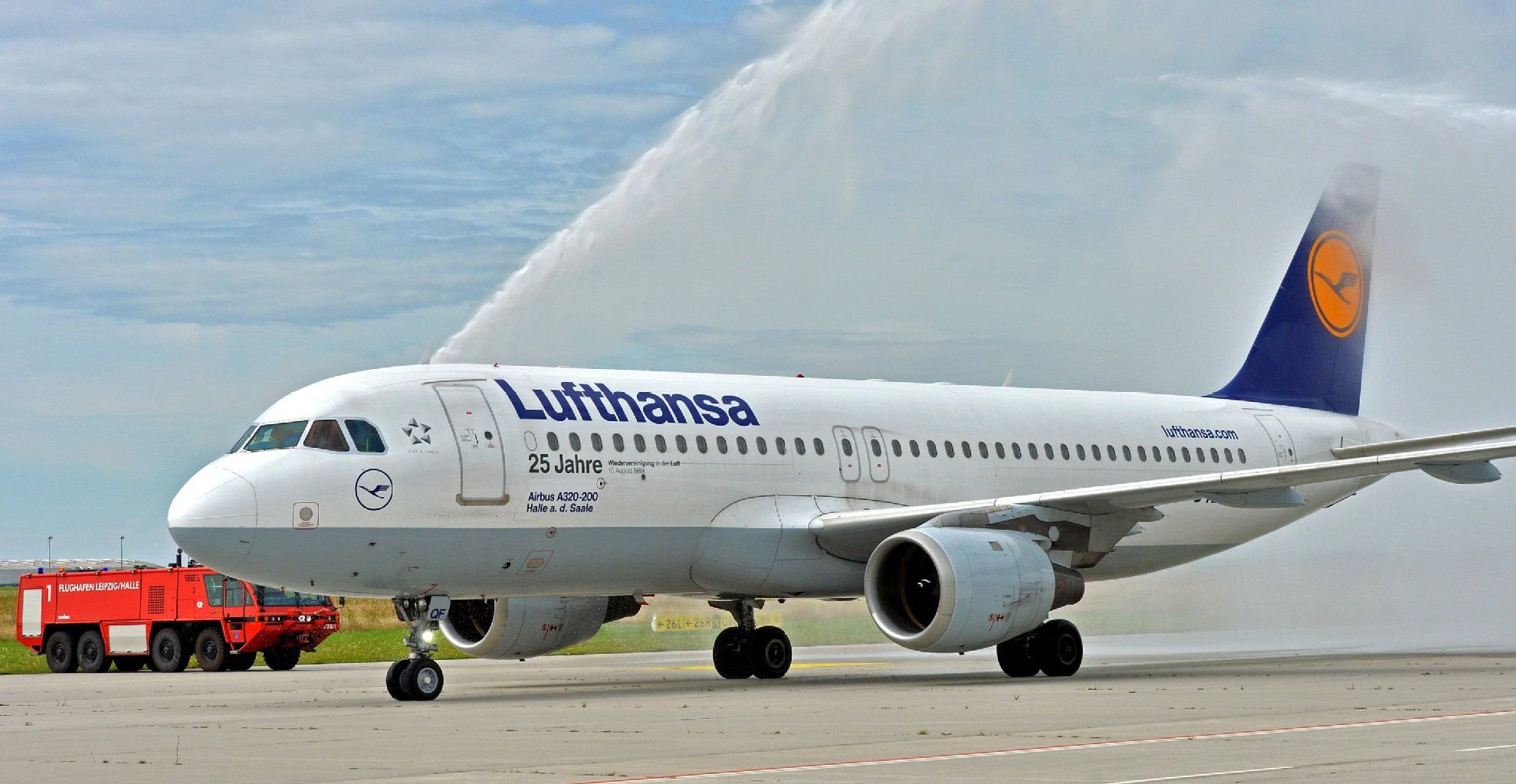 Mit einer Wasserdusche der Flughafenfeuerwehr wird am 10.08.2014 der Lufthansa-Airbus A320 mit dem Namen "Halle a. d. Saale" auf dem Flughafen Leipzig/Halle in Schkeuditz (Sachsen) begrüßt. Der Jubiläumsflug von Frankfurt am Main nach Leipzig erinnert an 25 Jahre deutsch-deutschen Linienverkehr der Lufthansa.
