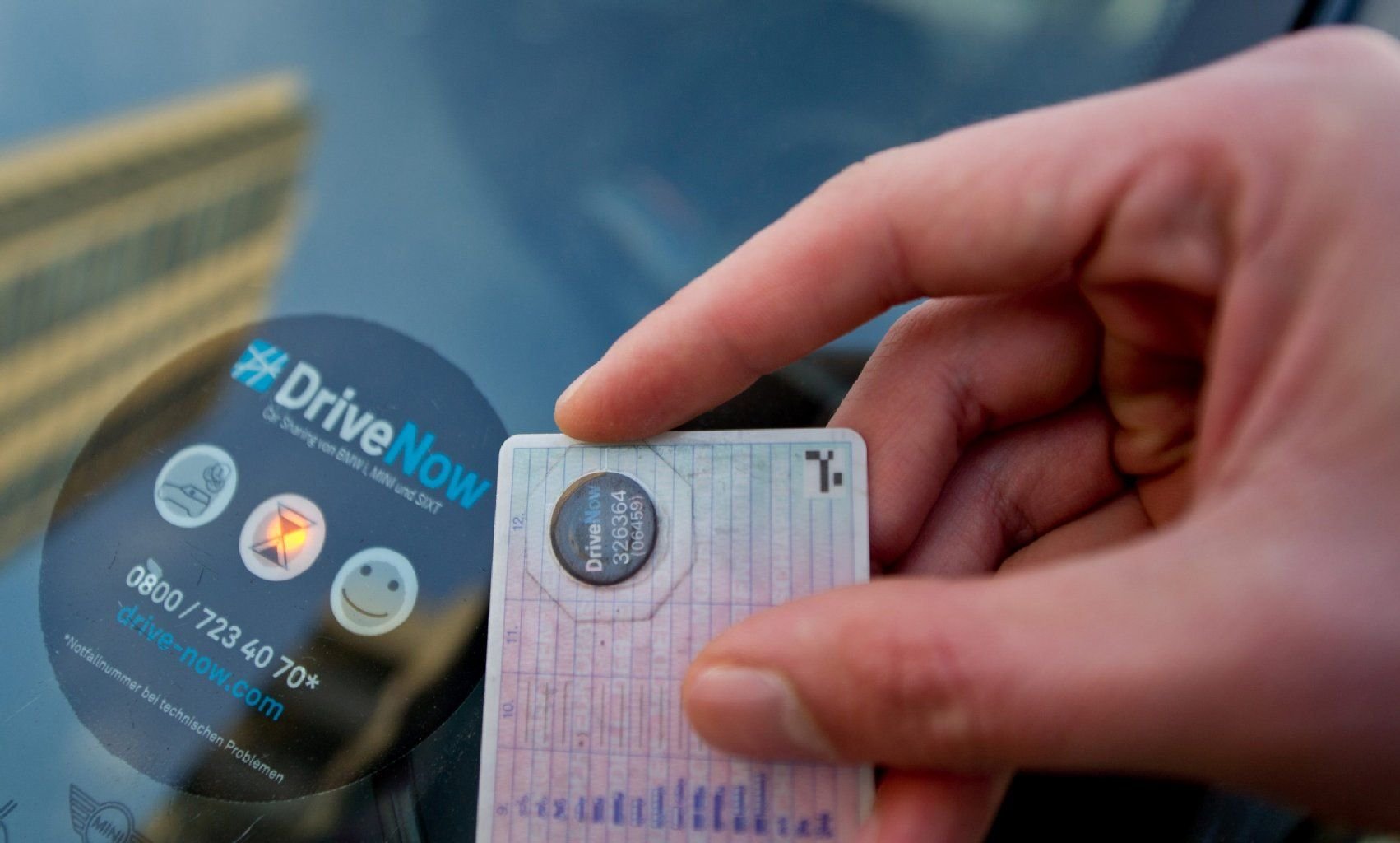 So funktioniert das System bei „DriveNow“: Auf dem Führerschein wird ein Identifikationssticker angebracht, diesen mus man vor den dazugehörigen Sticker auf der Windschutzscheibe des Leihwagens halten.