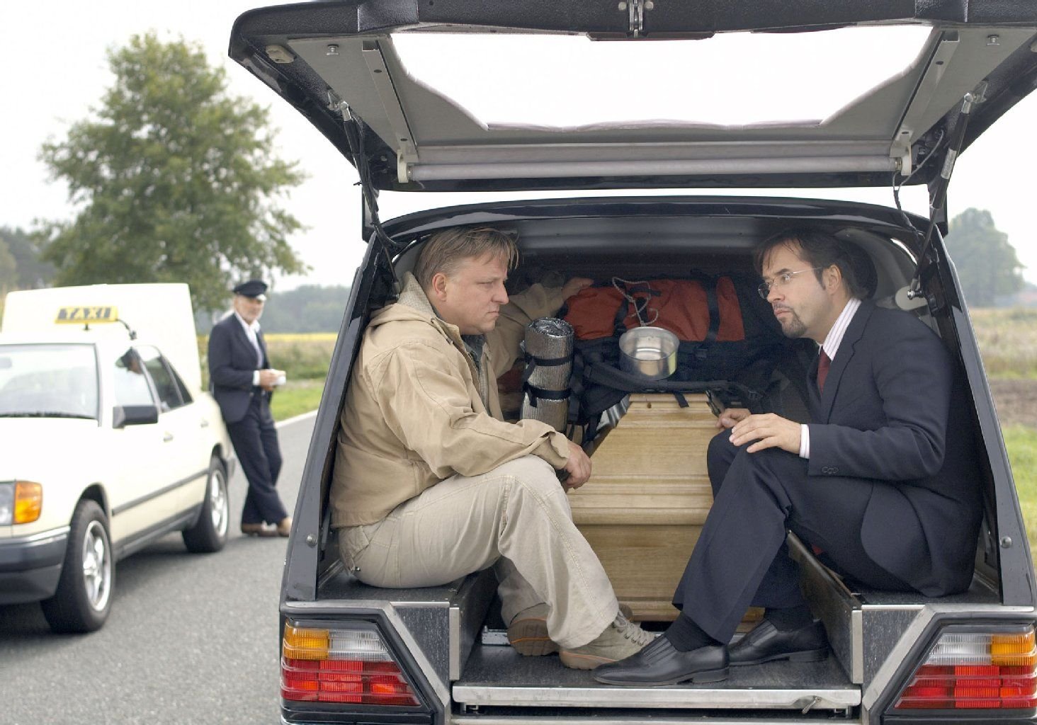 Frank Thiel (Axel Prahl) und Professor Dr. Karl-Friedrich Boerne (Jan Josef Liefers) aus dem Münsteraner Tatort. Thiel fährt Fahrrad, Boerne liebt Nobelkarren und Sportwagen.