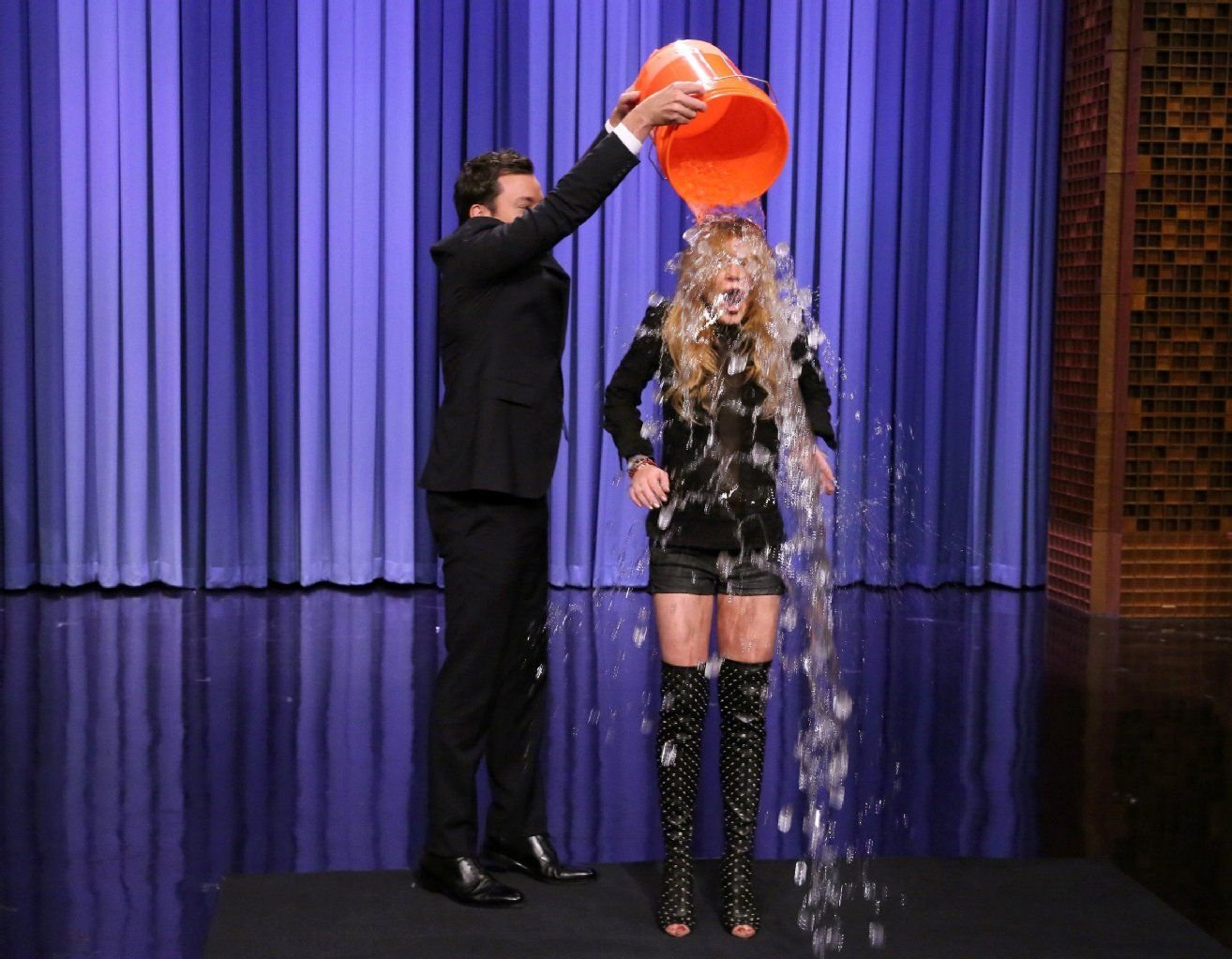 Auch Lindsay Lohan macht sich nass: Die Schauspielerin ließ sich in der „The Tonight Show Starring Jimmy Fallon“ vom Moderator persönlich einen Eimer Eiswasser über den Kopf schütten.