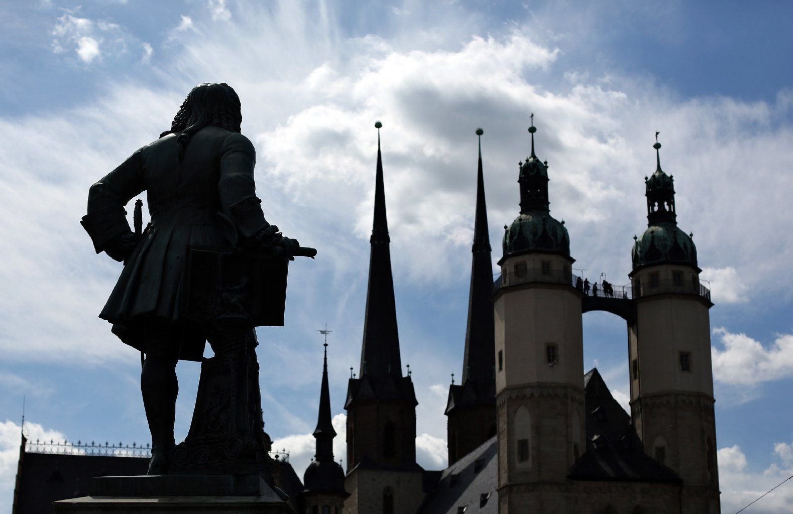 Das Händeldenkmal steht vor der Kulisse der Marktkirche in Halle (Saale).