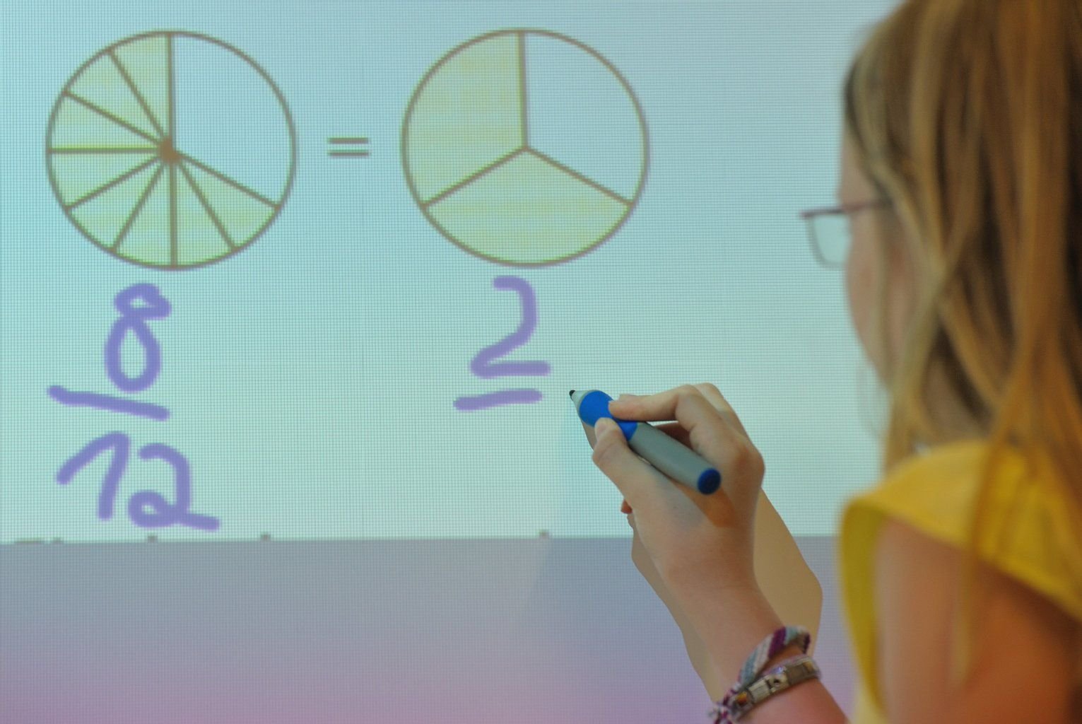 Eine Schülerin einer sechsten Klasse schreibt auf einem sogenannten «Interactive Whiteboard».