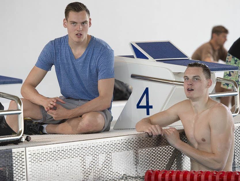 Hendrik Ulrich geschwächt am Beckenrand, sein Bruder Marek im Wasser.