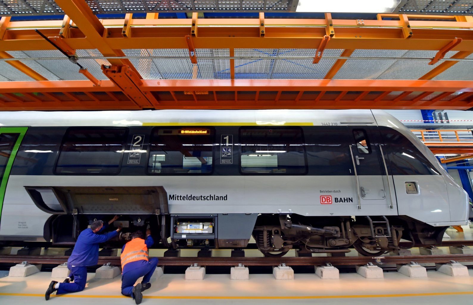 Zwei Mechaniker begutachten einen Triebwagen der S-Bahn Mitteldeutschland in der neuen Werkstatthalle der DB Regio Südost in Halle/Saale.