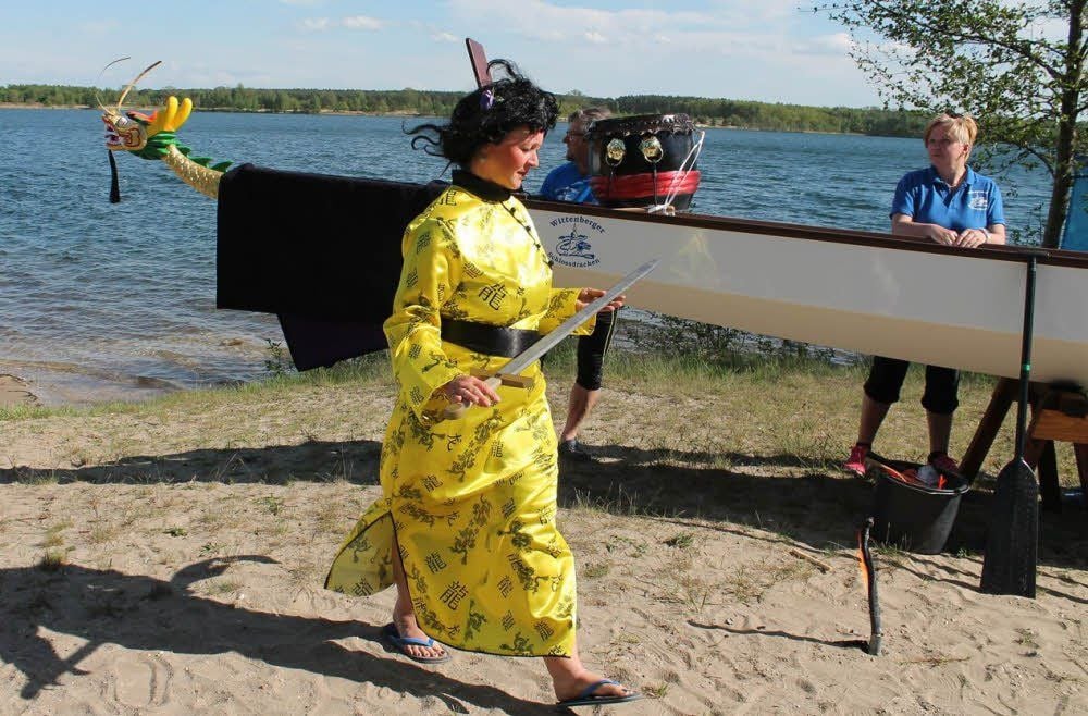 Einem Ritual entsprechend schreitet eine Chinesin, alias Yvette Raiskup, mit einem Schwert das Boot ab.