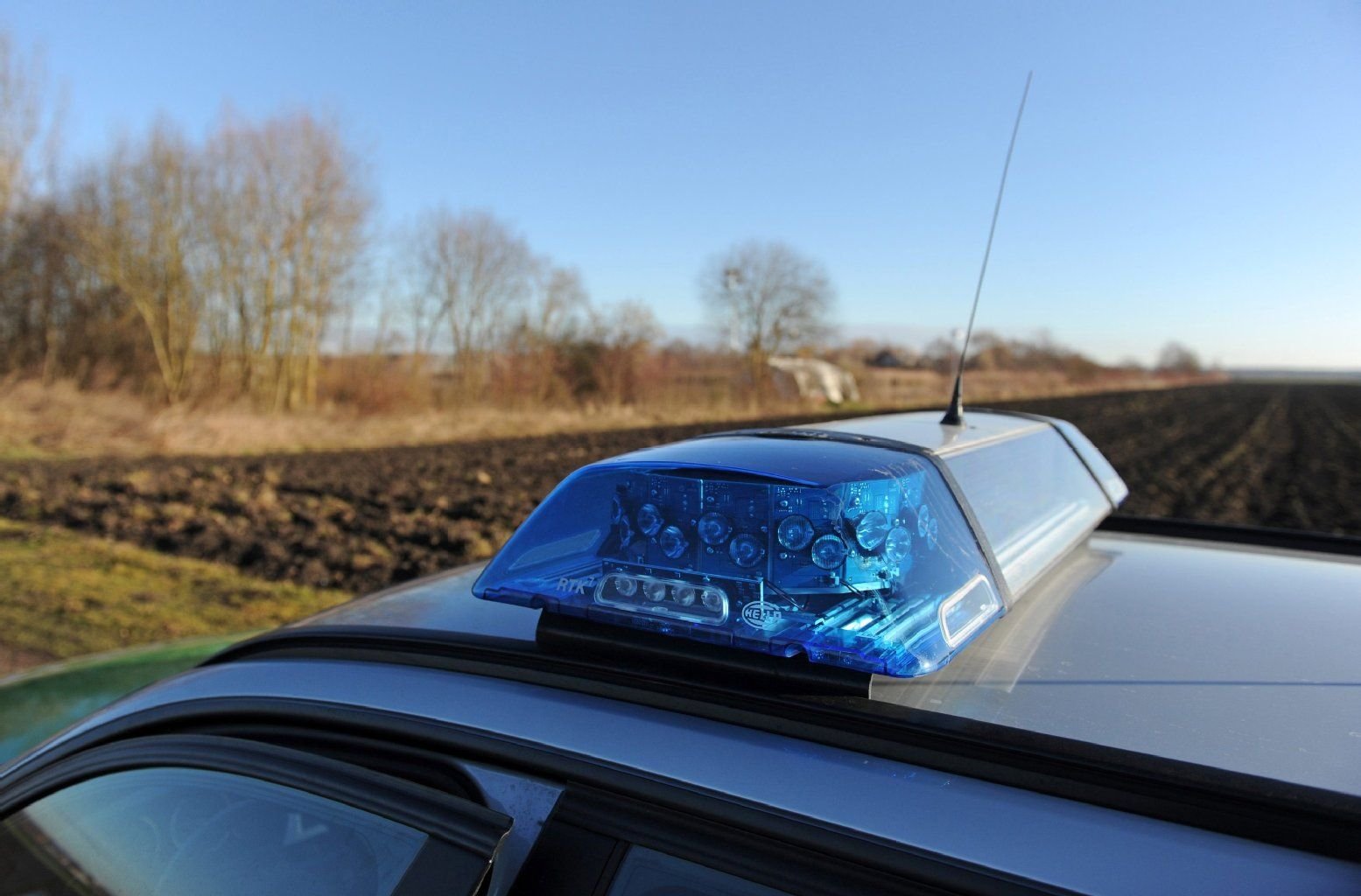 Ein Polizeiauto steht am Ufer des Rathei-Weihers in Bayern. Am Vortag hatten zwei Angler in dem Weiher eine Mädchenleiche gefunden. Ein Verdächtiger wurde inzwischen festgenommen.