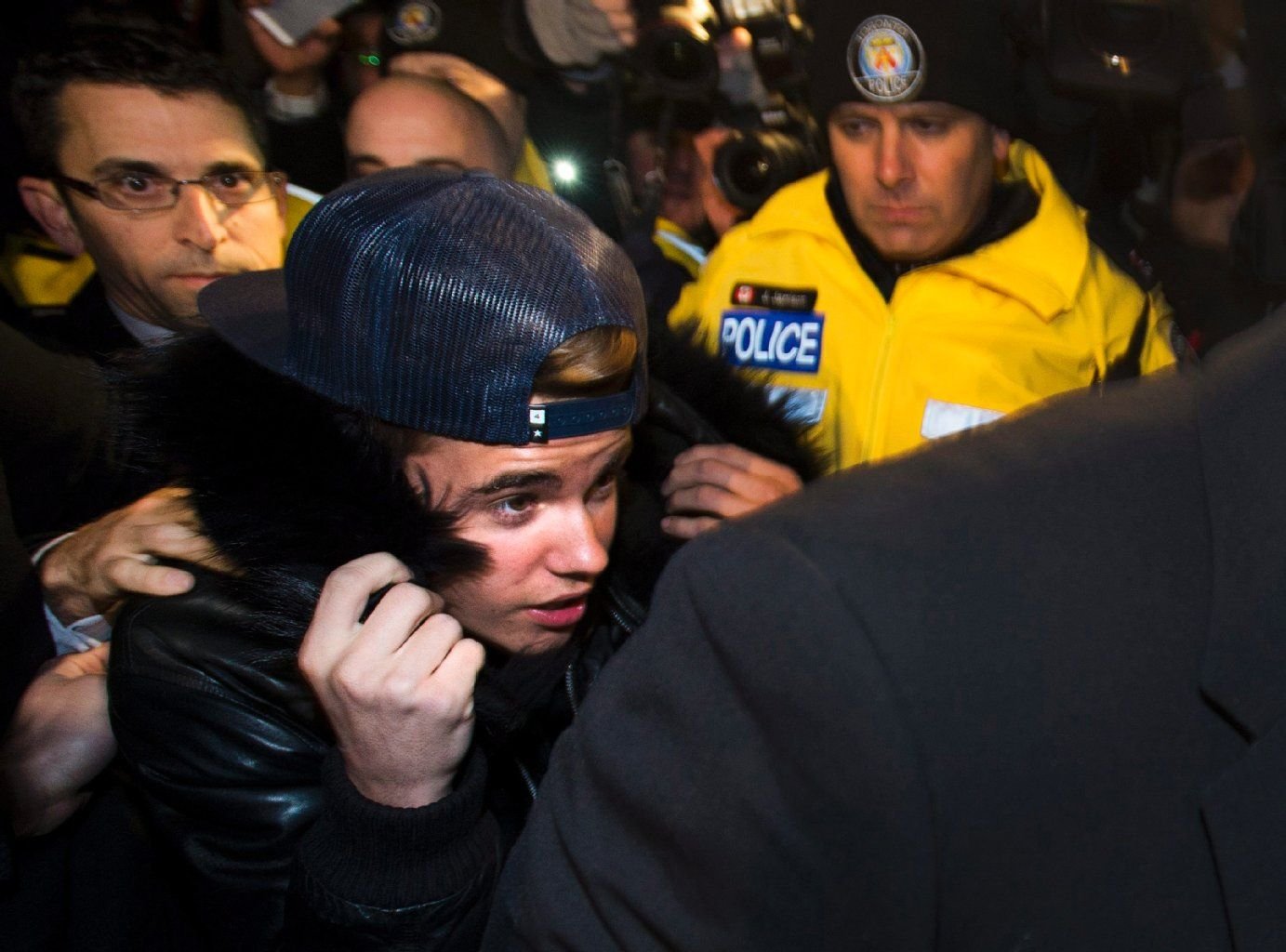 Justin Bieber muss oft (wie hier Ende Januar in Toronto) von seinen Bodyguards und Fahrern durch eine Paparazzi-Menge geschleust werden. Jetzt wurden zwei seiner Angestellten festgenommen.