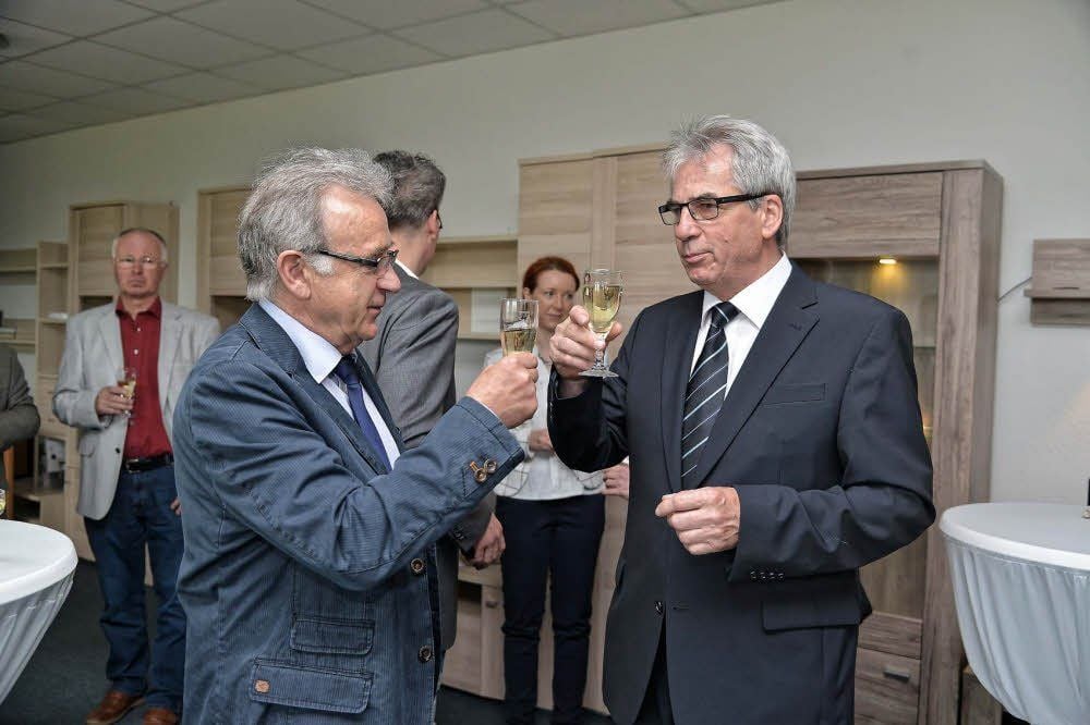 Eckhard Gips und Klaus Zehle stoßen mit ihren Gästen auf das Firmenjubiläum an.