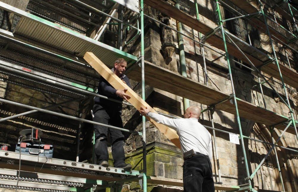 Die Zimmerleute Klaus Hosang und Tino Belling von der Baubetriebe Quedlinburg GmbH mit einem neuen Dachbalken.