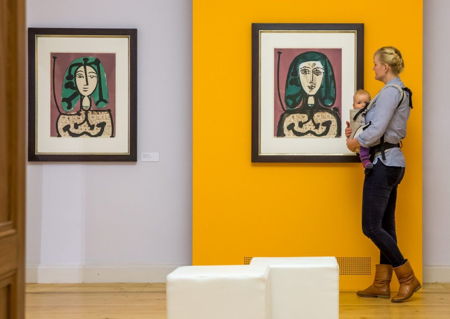 Eine junge Frau mit Kind betrachtet im Kunsthaus Apolda (Thüringen) Bilder von Pablo Picasso.