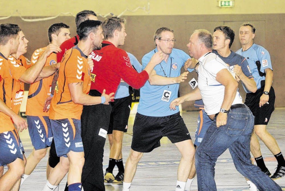 Bernburgs Sportlicher Leiter Enrico Nefe (im weißen T-Shirt) hat die Beherrschung verloren und muss besänftigt werden.