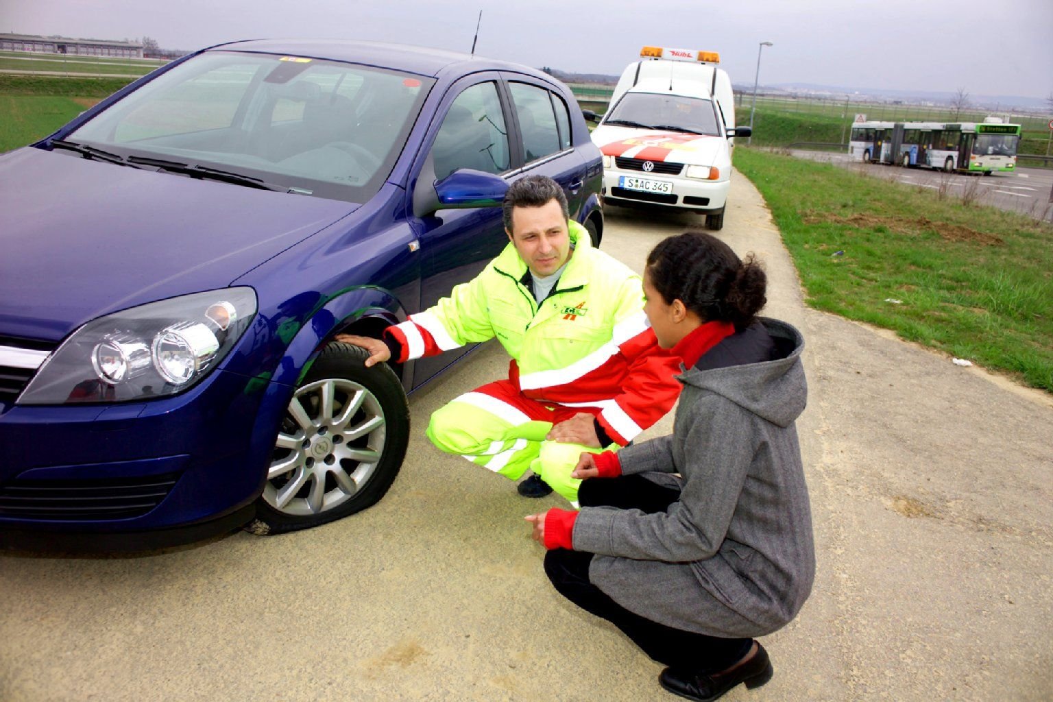 Der Reifen ist platt, das Auto muss stehen bleiben. Ein ACE-Helfer sieht sich den Schaden an.