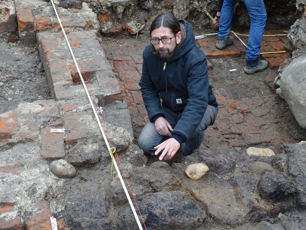 Der Archäologe Holger Rode vor der alten Mauer aus Raseneisenstein in Kemberg. In die älteren dunkleren Mauerreste sind in späteren Jahrhunderten mit einem weiteren Keller auch Ziegelsteine eingebaut worden.
