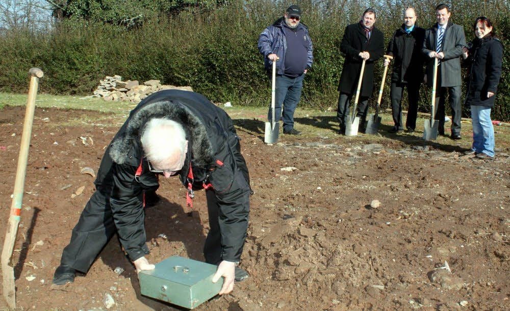 Pfalzarchäologe Michael Dapper (vorn) grub am Montag eine Kassette mit ein. Darin befanden sich - sicher in einer Glasflasche verwahrt - ein Artikel der MZ über das Projekt und eine nachempfundene ottonische Urkunde.