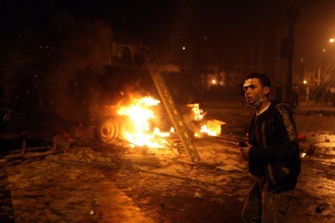 Ein Ägypter geht in Kairo an einem brennenden Fahrzeug vorbei. (FOTO: DPA)
