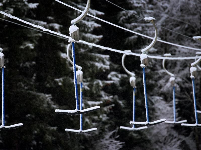 Bügel eines Schleppliftes hängen in schneebedeckter Landschaft. Wegen der Maßnahmen um das Coronavirus müssen Skilifte geschlossen bleiben. Foto: Karl-Josef Hildenbrand/dpa