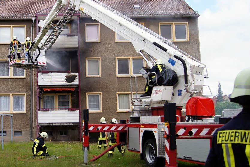 Mitglieder der Jessener Feuerwehr löschen von der Hubrettungsbühne aus auf der einen Hausseite, während anderen Wehren auf der anderen Seite ebenfalls das Feuer bekämpfen.