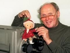 Der Trickfilmmacher Gerhard Behrendt, der die Figur des Sandmännchens für den Deutschen Fernsehfunk der DDR erfand, zeigt in der Media City Adlershof eine 25 Jahre alte Originalfigur vor einer historischen Studiokamera (Archivfoto vom 04.11.1999). (Foto: dpa)